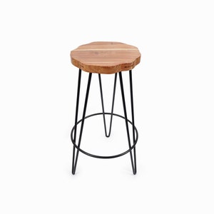 May include: A black metal bar stool with a round wooden seat. The seat has a natural wood finish and a unique shape.