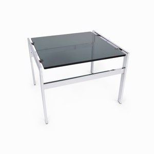 Op de afbeelding: Een bijzettafel van chroom en glas met een donkergrijs glazen blad en een chroom frame.