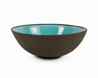 May include: A brown ceramic bowl with a turquoise blue glaze on the inside.