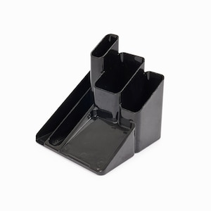 Pode incluir: Organizador de mesa de plástico preto com quatro compartimentos. O organizador tem uma base retangular e três compartimentos verticais.