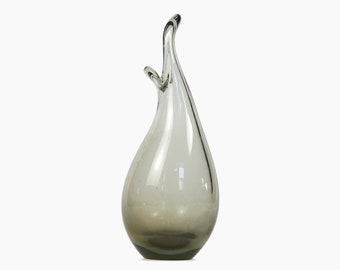 May include: A clear glass vase with a gray ombre effect. The vase has a unique, organic shape that resembles a teardrop.