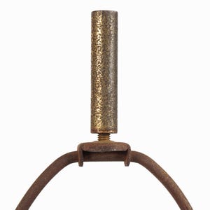 May include: Close-up of a vintage lamp component. The image shows a textured, cylindrical brass rod connected to a curved, rusty metal frame. The design features a threaded screw for attachment, suggesting a repair or restoration project.