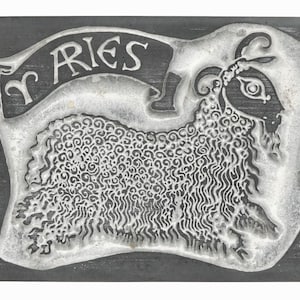 Puede incluir: Una baldosa de pizarra negra con una imagen blanca del signo del zodíaco Aries, un carnero con cuernos rizados, y la palabra "Aries" escrita en una pancarta sobre el carnero.