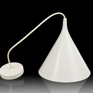 May include: A white, cone-shaped pendant light fixture with a matching white cord and ceiling mount. The light has a smooth, glossy finish and a minimalist design, suitable for modern interiors. The fixture is suspended against a black background.