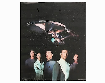 Puede incluir: Un póster vintage con el reparto de la serie de televisión original de Star Trek de pie frente a la nave espacial Enterprise. El póster es negro con un fondo azul oscuro y presenta la nave espacial Enterprise en la parte superior central del póster. Los miembros del reparto están de pie en fila, con el Capitán Kirk en el centro.