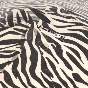 May include: Black and white zebra patterned bowl with a signature that reads "S.Hawkins '01".