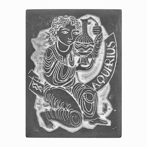 Può includere: Illustrazione in bianco e nero del segno zodiacale Acquario. L'immagine rappresenta una figura che versa acqua da una brocca, con la parola "ACQUARIO" inscritta su uno stendardo.