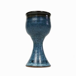 May include: A blue ceramic goblet with a flared base and a black rim. The goblet has a speckled glaze.