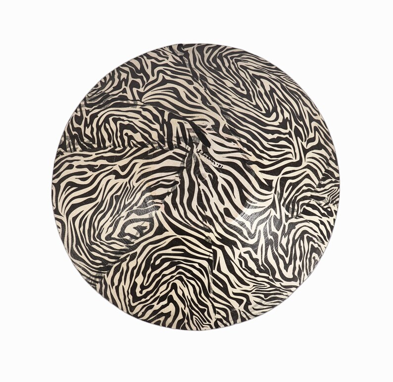 May include: A round, black and white zebra print decorative plate.
