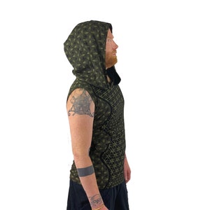 May include: A sleeveless hooded shirt with a black and green geometric pattern. The hood is pulled up and the shirt is worn by a person.