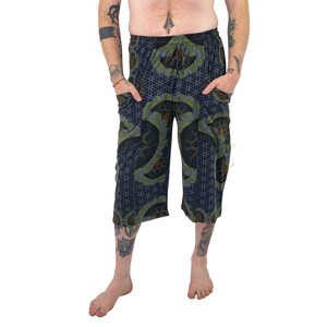May include: Black and green patterned pants with a drawstring waist and pockets. The pants have a geometric design with a flower of life pattern.