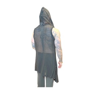 May include: A sleeveless, dark gray hooded vest with a distressed hem. The vest is long, reaching below the waist, and has a loose, flowing fit. The fabric appears to be lightweight and slightly sheer. The back of the vest features a subtle, textured pattern.