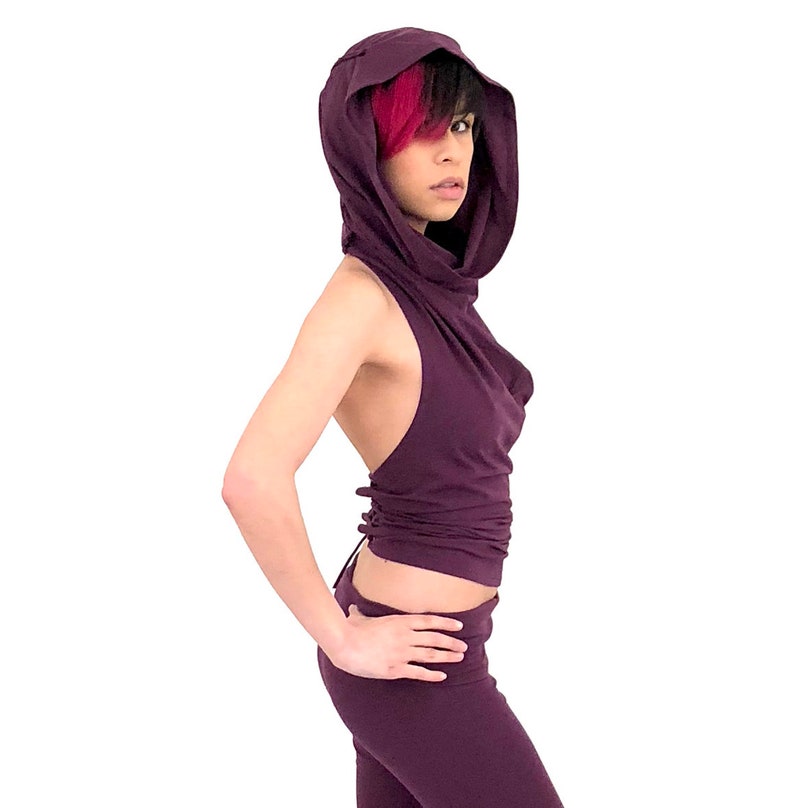 Puede incluir: Un top morado sin mangas con una capucha grande. El top est&aacute; hecho de una tela suave y el&aacute;stica y tiene un ajuste holgado. La capucha se re&uacute;ne en el cuello y se puede llevar arriba o abajo.