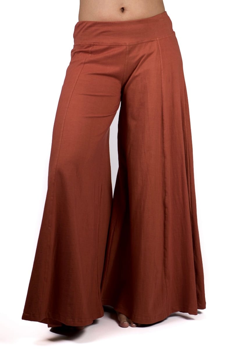 May include: Wide-leg pants in a rust brown color. The pants have a wide, flowing silhouette and a comfortable, relaxed fit.