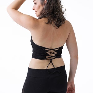 May include: A black halter top with a lace-up back detail. The top is made of a soft, stretchy fabric and is perfect for yoga, dance, or everyday wear.