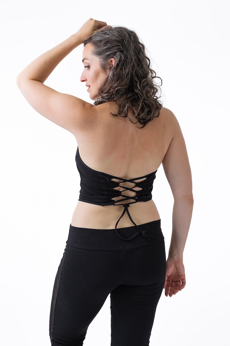 May include: A black halter top with a lace-up back detail. The top is made of a soft, stretchy fabric and is perfect for yoga, dance, or everyday wear.