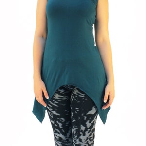 May include: A teal sleeveless top with a high neckline and a high-low hemline. The top is paired with black and gray patterned leggings.