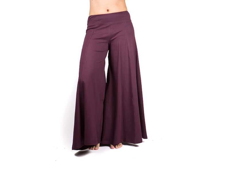 May include: A pair of wide-legged pants in a deep purple color. The pants have a wide, flowing silhouette and a comfortable, relaxed fit.