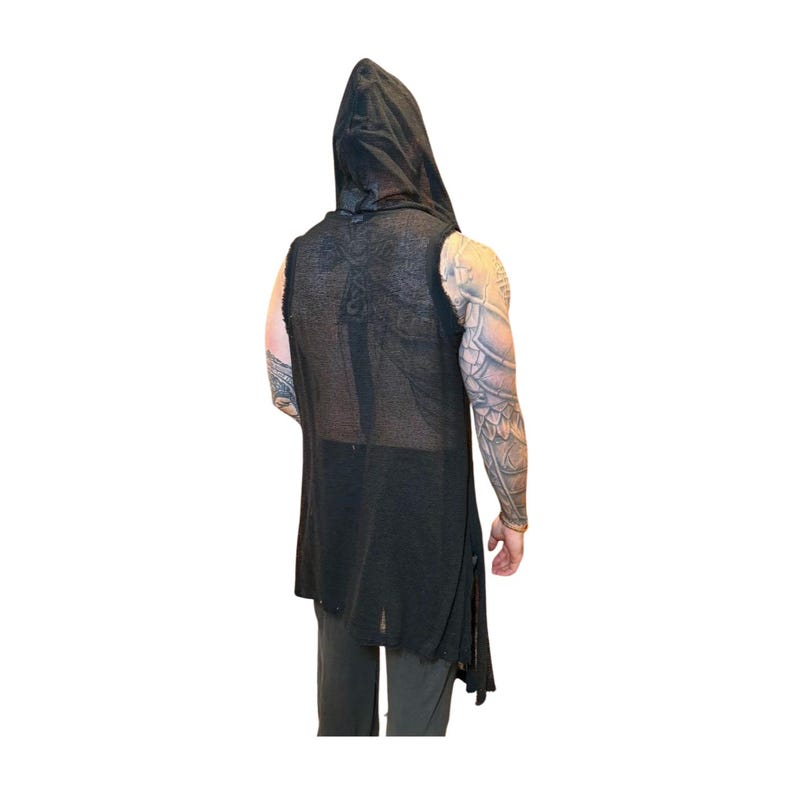 May include: Black sleeveless hooded vest with a long, asymmetrical hem. The vest has a distressed, open-weave design and a draped hood. The garment is made of a lightweight fabric, suitable for layering. The vest is shown from the back.