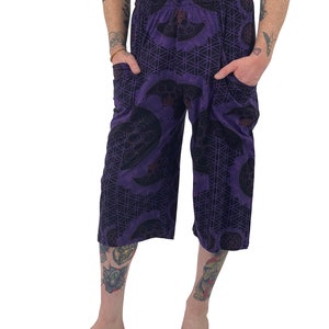 May include: Purple printed pants with a geometric pattern and a drawstring waist.