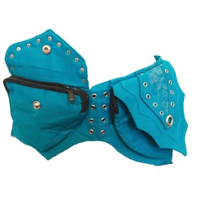 May include: A turquoise blue fabric belt with multiple pockets and decorative metal eyelets. The belt has a zippered pocket and a flap with a floral design.