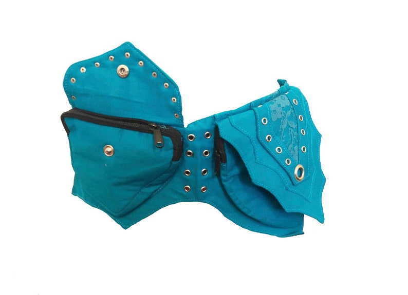 May include: A turquoise blue fabric belt with multiple pockets and decorative metal eyelets. The belt has a zippered pocket and a flap with a floral design.