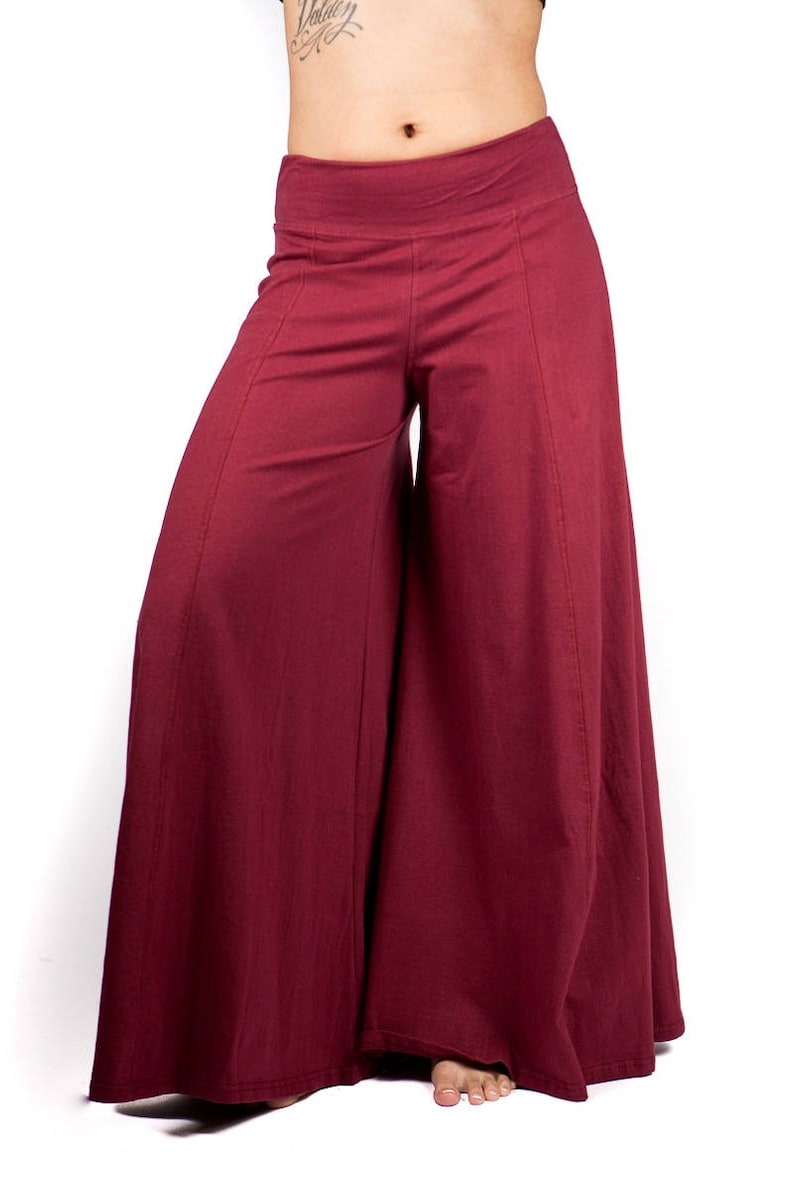 May include: Wide-leg pants in a deep burgundy color. The pants have a high waist and a flowing, loose fit.