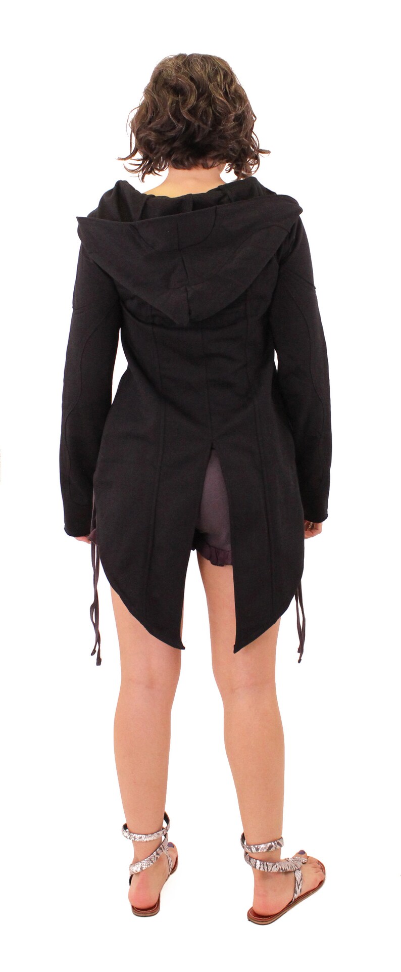 May include: A black hooded jacket with a long, flowing back and a split hem. The jacket has a drawstring at the waist and is made of a soft, comfortable fabric.