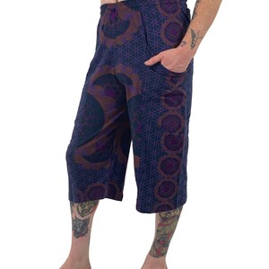 May include: Purple and brown patterned cropped pants with an elastic waistband and a pocket on the right side.