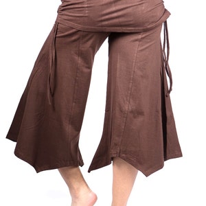 May include: Brown wide-leg pants with a gathered waistband and tie closures at the sides. The pants have a flared hemline.