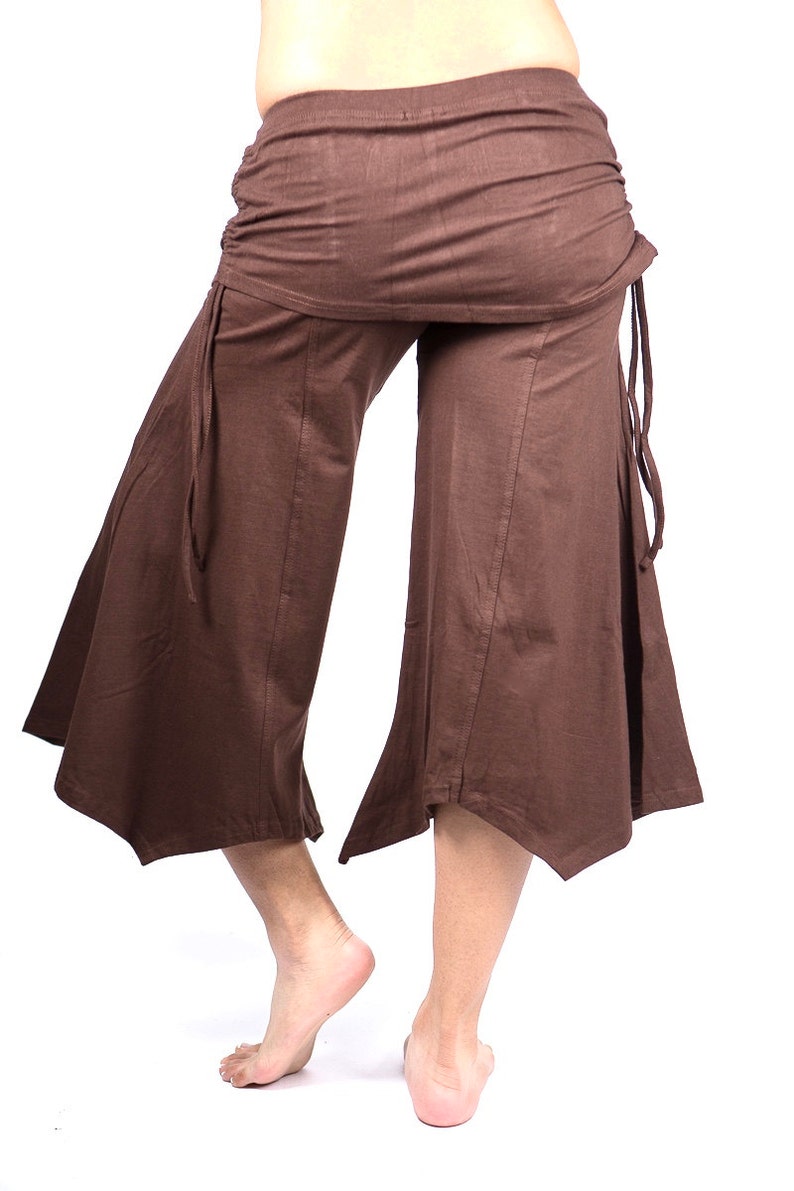 May include: Brown wide-leg pants with a gathered waistband and tie closures at the sides. The pants have a flared hemline.