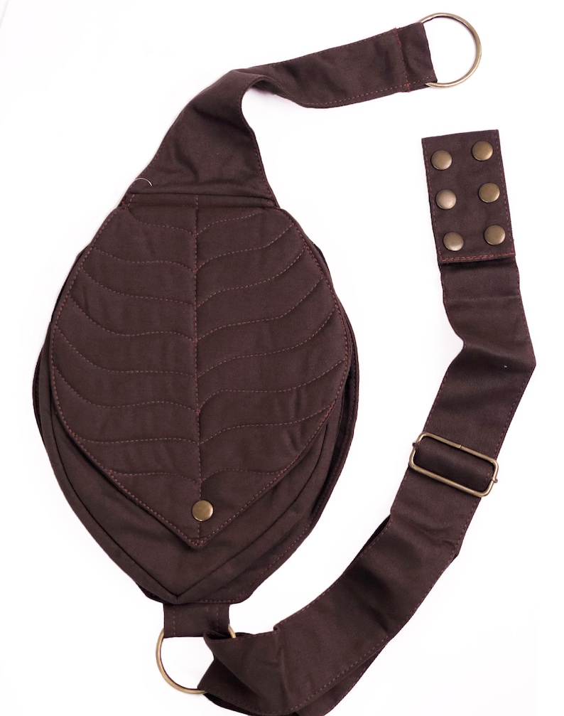 May include: A brown quilted leaf-shaped crossbody bag with a long adjustable strap and metal hardware.