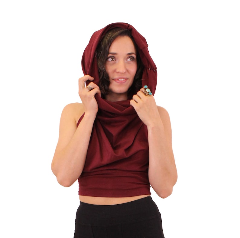 Puede incluir: Una blusa de cuello de tortuga color burdeos con capucha. La blusa est&aacute; hecha de una tela suave y el&aacute;stica y tiene un corte holgado. La modelo lleva la blusa con pantalones negros.