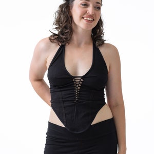 May include: A black halter top with a lace-up detail in the front. The top is fitted and has a low neckline.