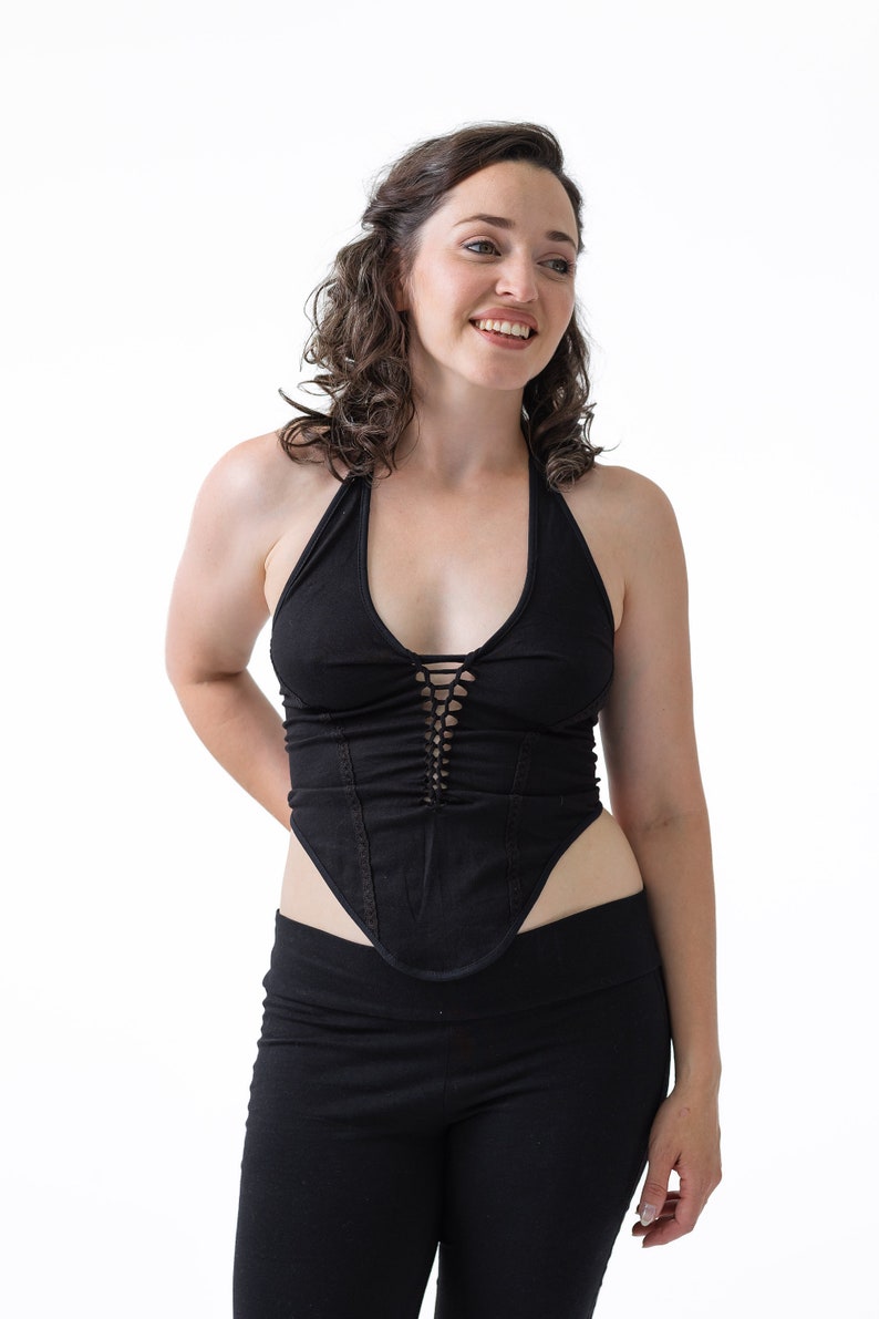 May include: A black halter top with a lace-up detail in the front. The top is fitted and has a low neckline.