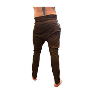 Puede incluir: Pantalones har&eacute;n marr&oacute;n oscuro con un ajuste relajado. Los pantalones tienen una cintura alta y una pernera c&oacute;nica. La tela parece ser un material suave y fluido. Los pantalones est&aacute;n dise&ntilde;ados para la comodidad y el estilo.