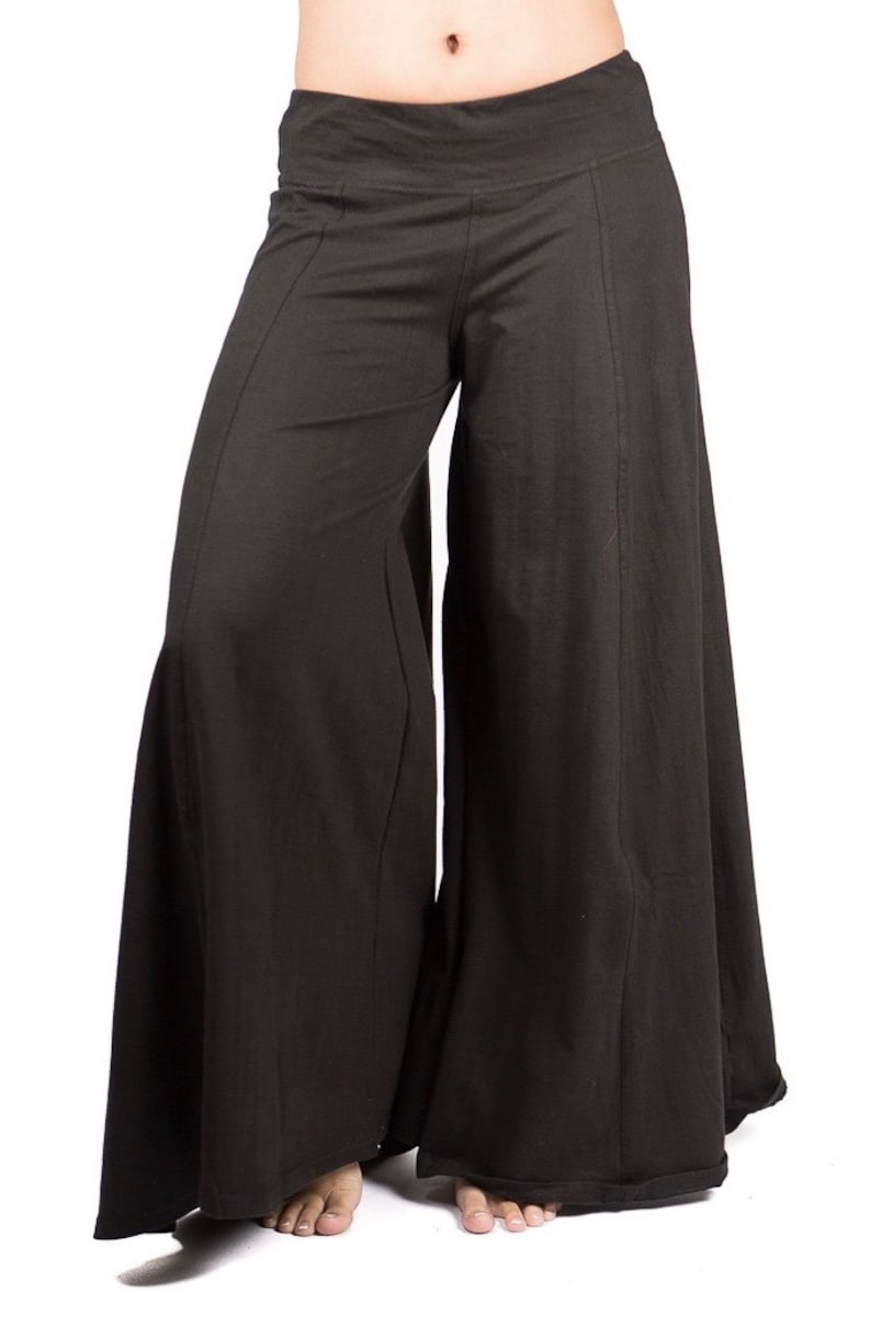May include: Black wide-leg pants with a wide, flowing silhouette. The pants have a simple design and a comfortable fit.