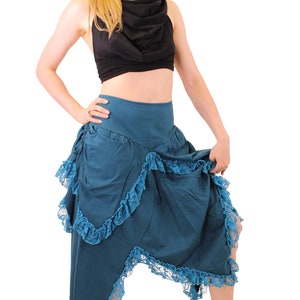 Puede incluir: Una falda azul turquesa con un dobladillo con volantes y un top negro. La falda tiene un bolsillo en el lateral y un ribete de encaje.