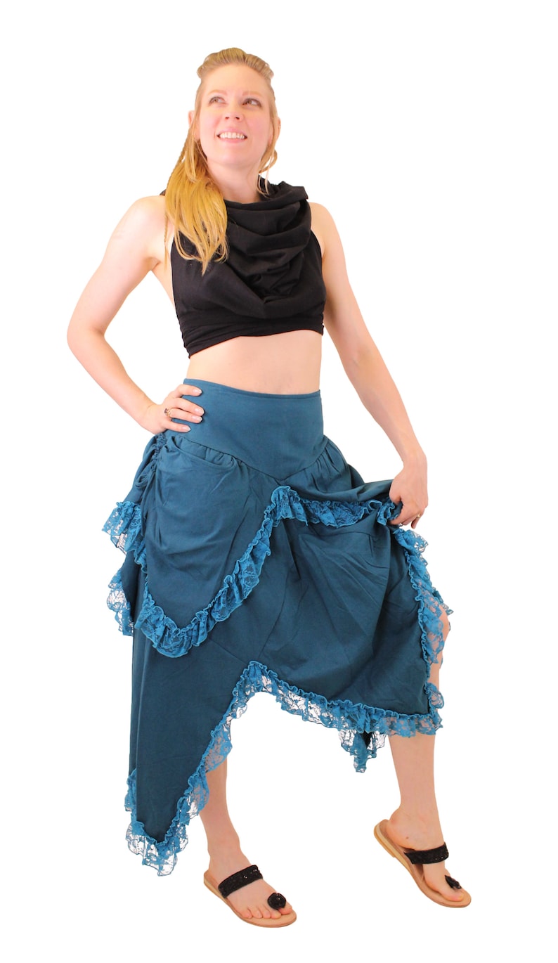 Puede incluir: Una falda azul turquesa con un dobladillo con volantes y un top negro. La falda tiene un bolsillo en el lateral y un ribete de encaje.