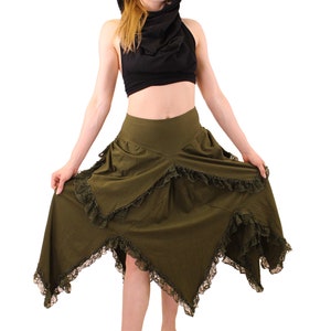 Puede incluir: Una falda verde con ribete de encaje negro y un top negro con capucha. La falda es asim&eacute;trica y tiene una cintura alta.