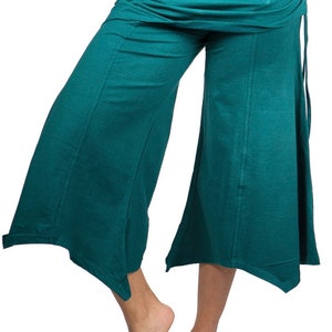 May include: Teal wide-leg pants with a gathered waistband and a slightly flared hem. The pants have a relaxed fit and are made of a soft, comfortable fabric.