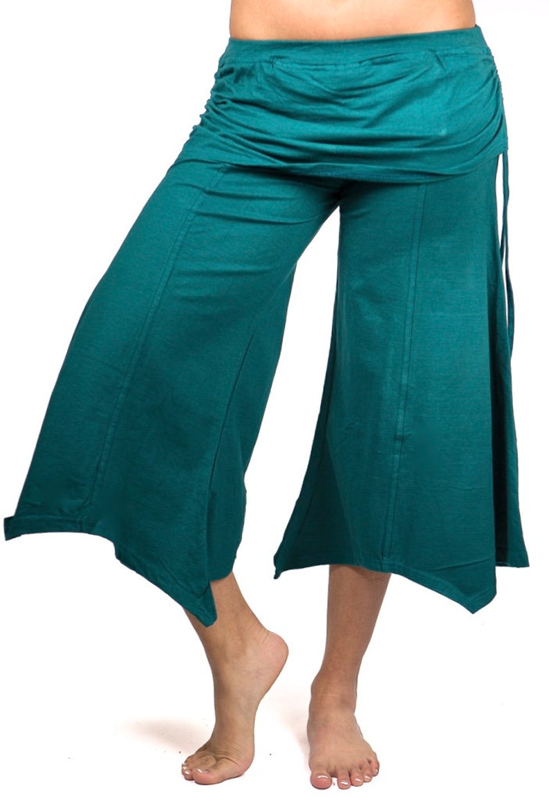 May include: Teal wide-leg pants with a gathered waistband and a slightly flared hem. The pants have a relaxed fit and are made of a soft, comfortable fabric.