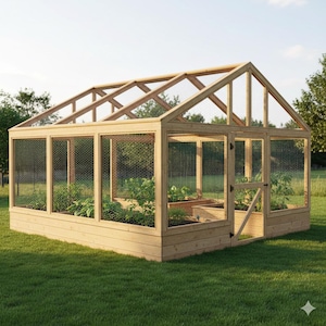 Puede incluir: Un invernadero de madera con techo a dos aguas y paneles de malla metálica. La estructura cuenta con una puerta y contiene parterres elevados con plantas. El invernadero está sobre un césped, ideal para jardinería.