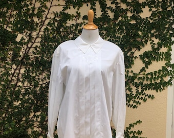 1990 Jones New York white long sleeve pleated blouse, crest embroidery