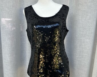 May include: A black sleeveless top with gold sequins. The top is on a white mannequin.