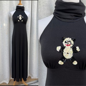 May include: A black halter maxi dress with a sequined panda bear design on the front. The dress has a mock neck and a fitted bodice.