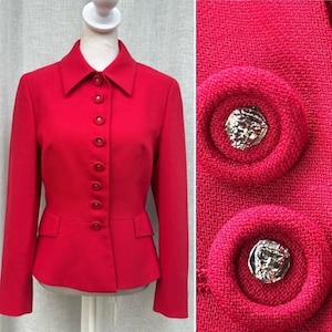 May include: A bright red blazer with a classic collar and button-down front. The blazer features a tailored fit with small pockets and decorative buttons. The close-up shows textured fabric and two large decorative buttons with silver-colored centers.