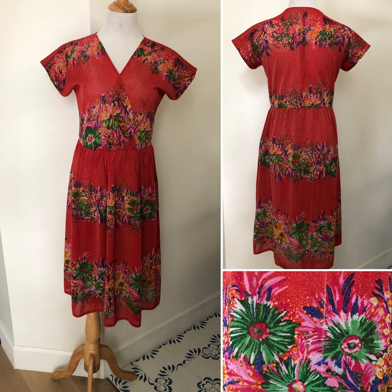 May include: A red midi dress with a floral print. The dress has a V-neckline, short sleeves, and a wrap-style bodice. The dress is made of a lightweight fabric and has a flowy silhouette.