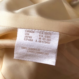 May include: A white fabric care label with the text "CANADA CA 02575 R.N. 61891 USA JAPAN ESPANA A-08.475402 100% LEINEN/LINEN/LINO" printed on it.