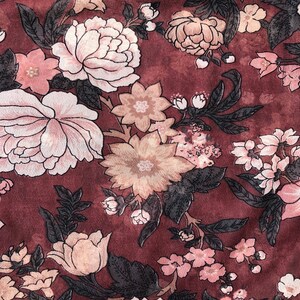 K&ouml;nnte beinhalten: Ein burgunderfarbener Stoff mit einem floralen Muster aus rosa, wei&szlig;en und beigefarbenen Blumen. Die Blumen sind in einem sich wiederholenden Muster angeordnet und haben eine Vintage-&Auml;sthetik.